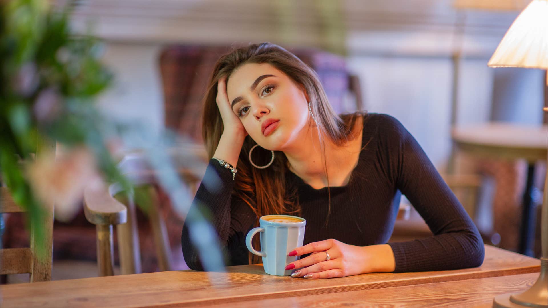 a lazy woman tells people she is waiting for someone while at a cafe