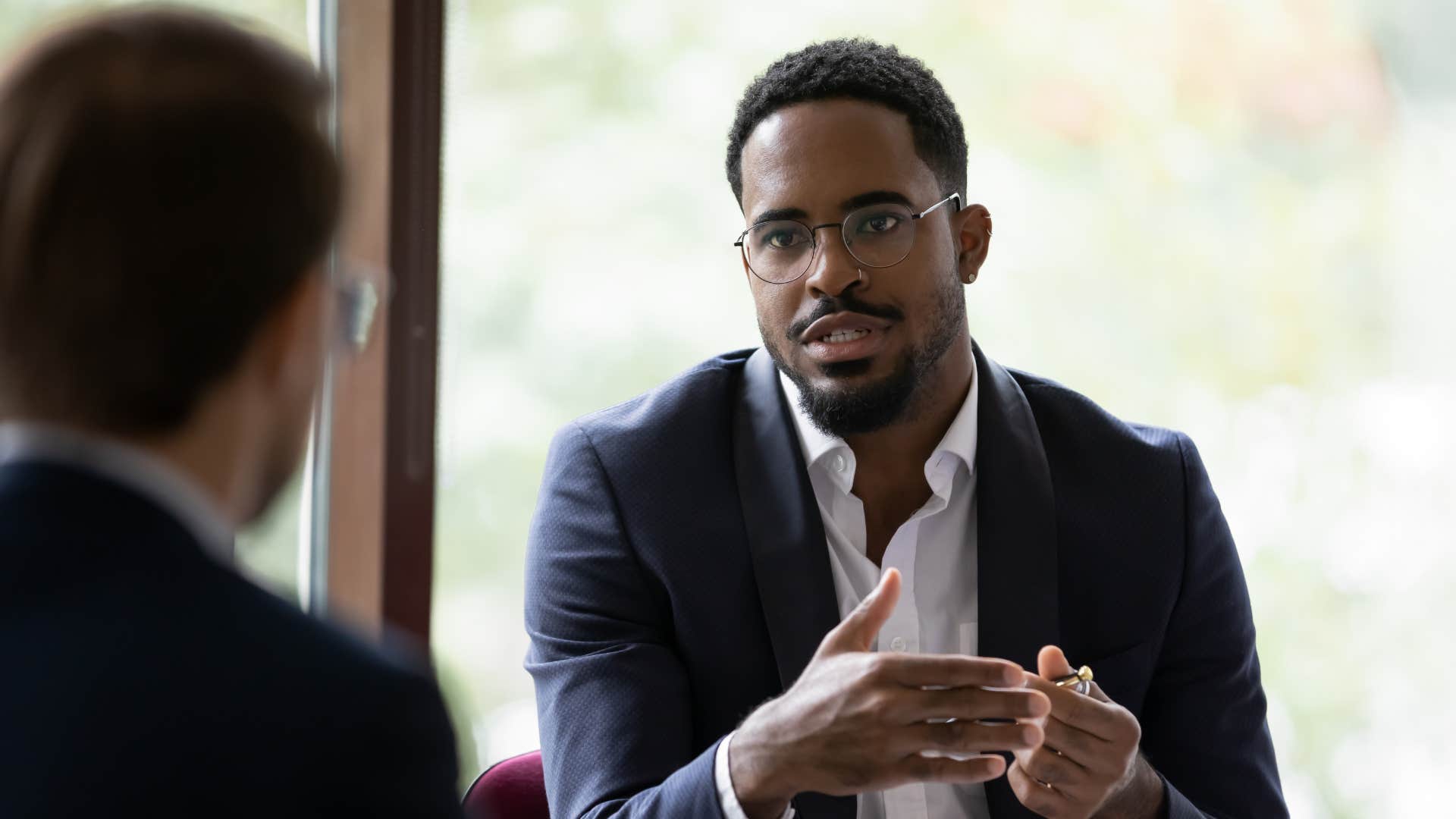 businessman telling colleague he works better under pressure