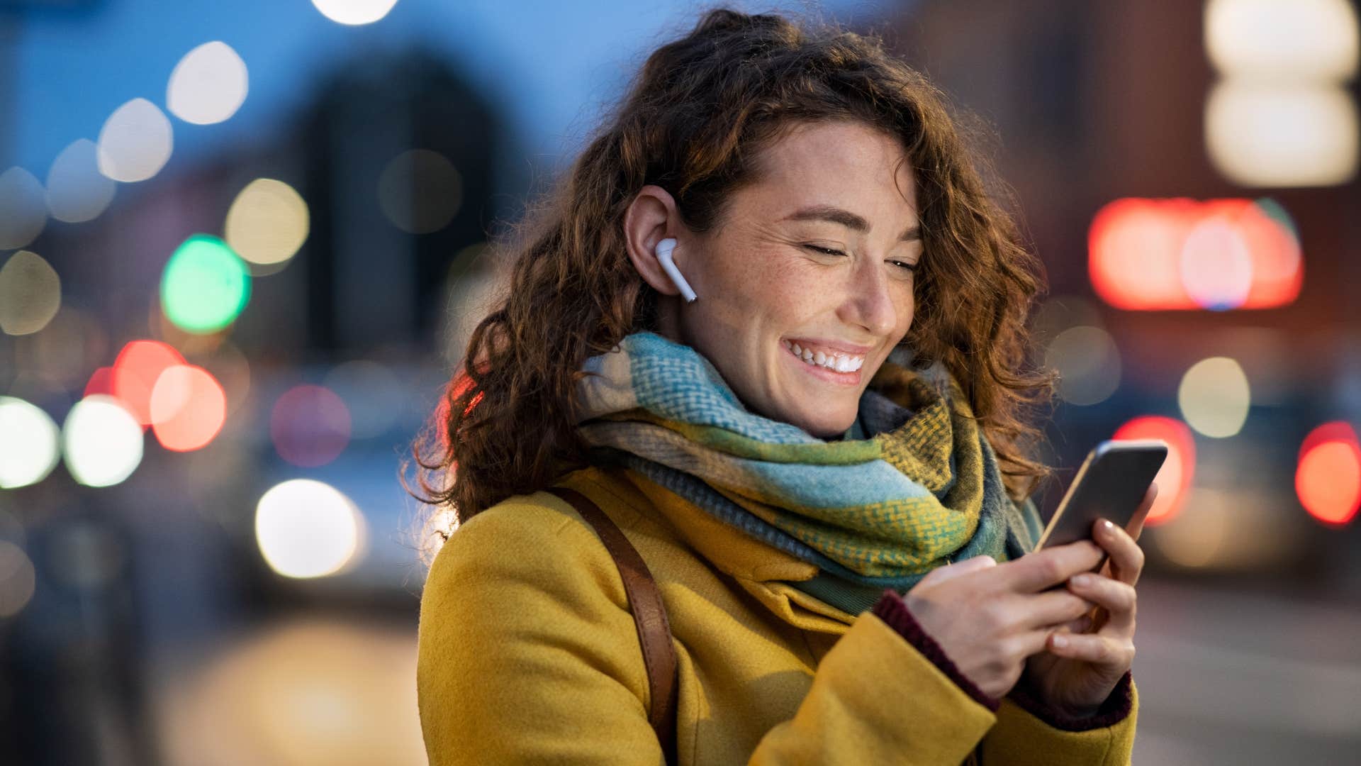 woman smiling with headphones as she loves hearing partner's voice 