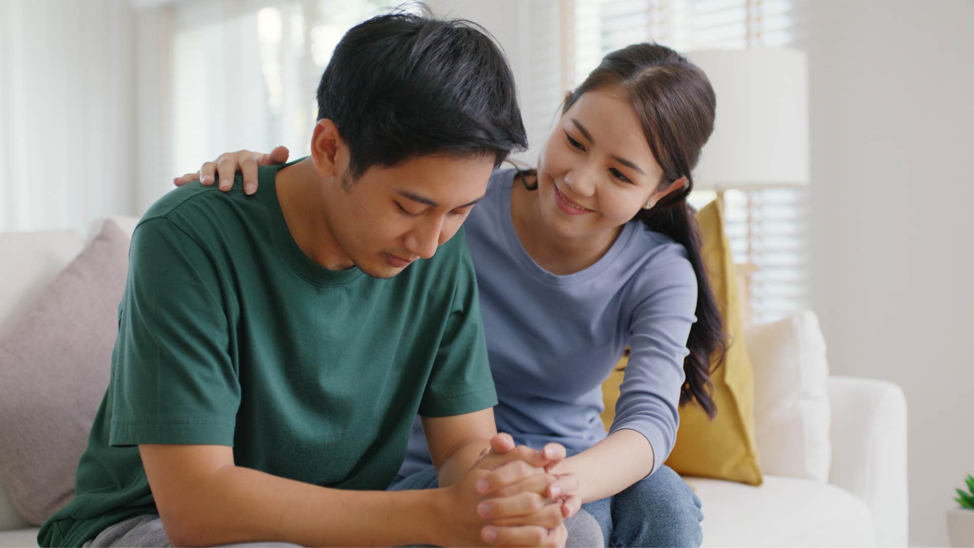 woman comforting man in green shirt as she smiles and says i'm proud of you