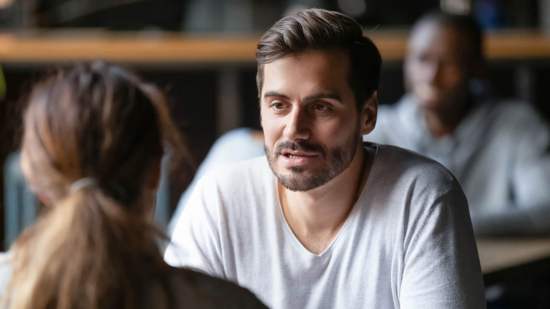 man saying i'm fine please don't worry about me as he sits across from woman