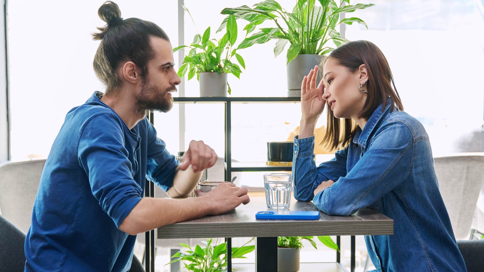 man and woman in denim outfits sitting across from one another as woman says you've changed