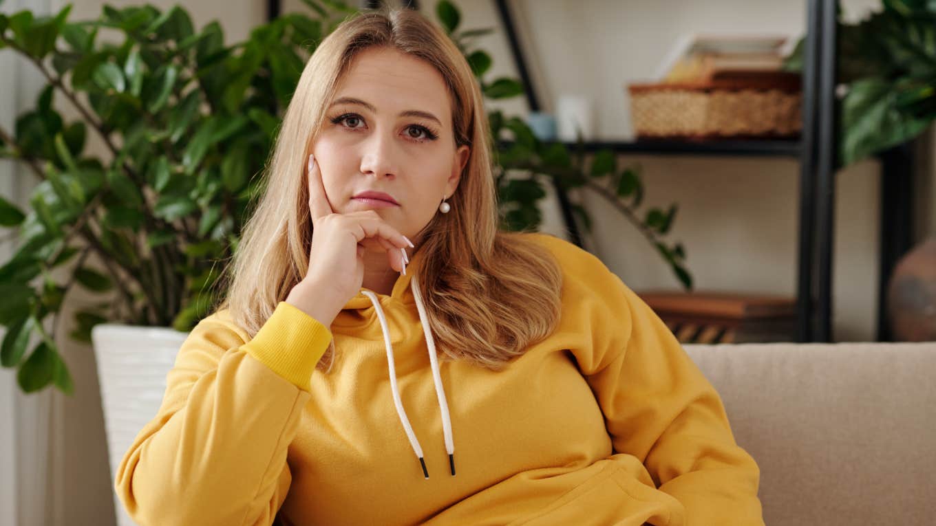 serious woman sitting on couch in living room