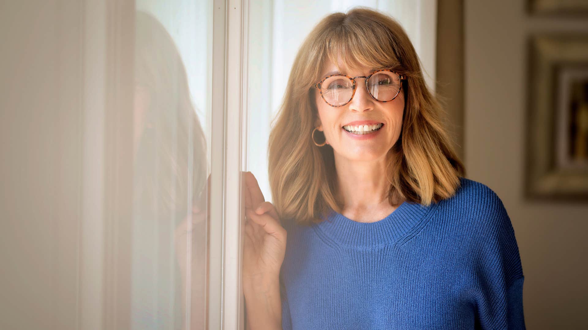 woman in blue shirt and glasses smiling as she's abnormally quick at adapting to societal changes