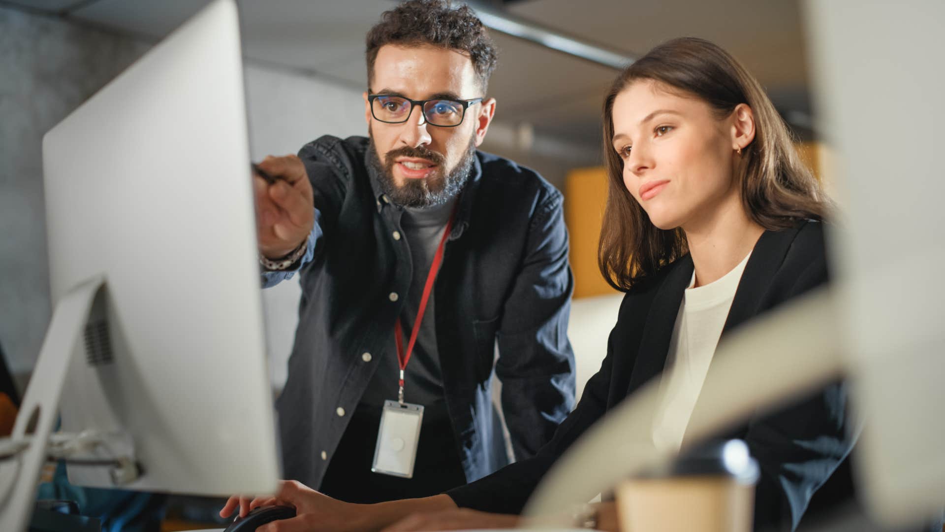 man in dark denim jacket being a secret innovator as he points at screen