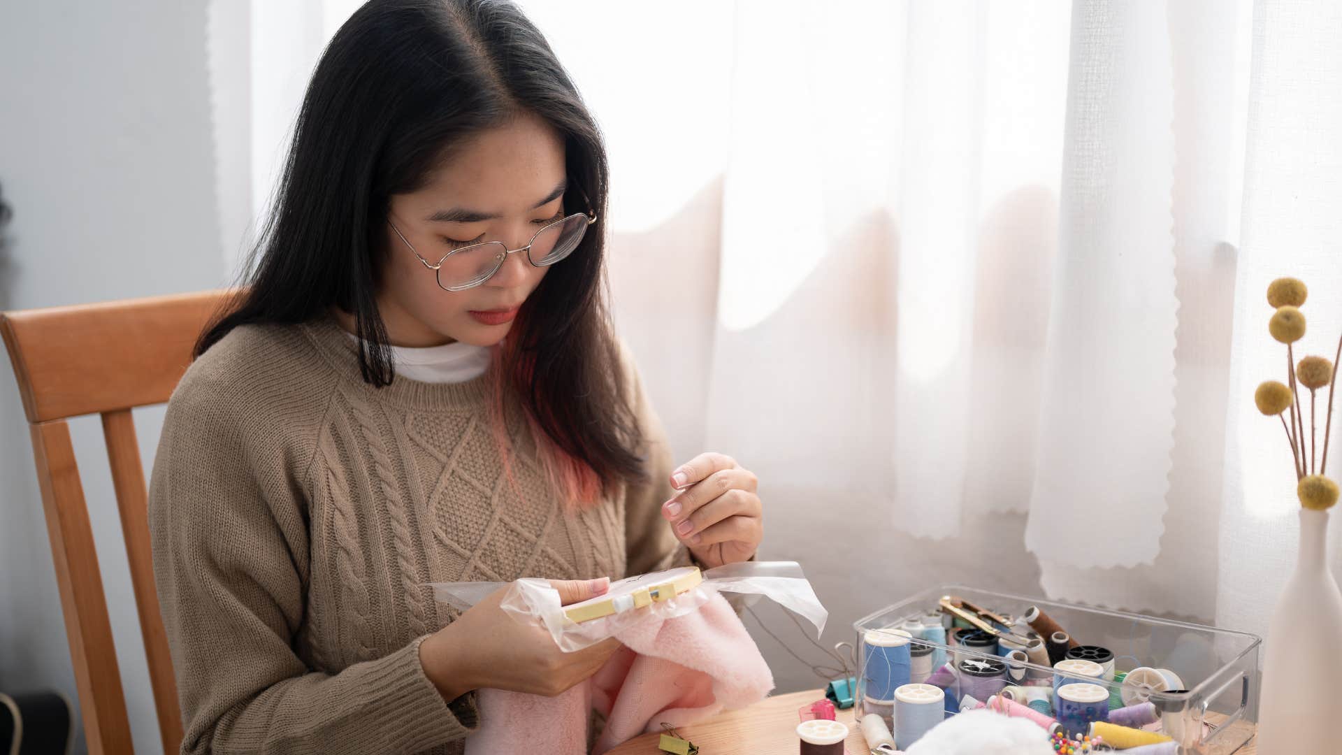 an introverted woman is focused on her task of sewing