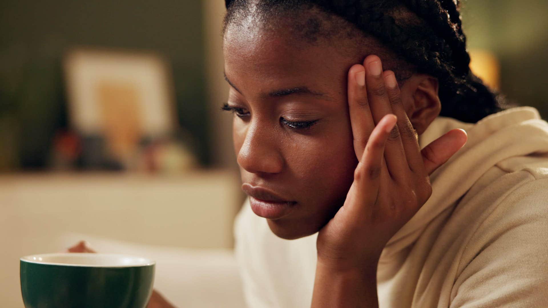 Woman who's aware of their biases looking stressed at home.