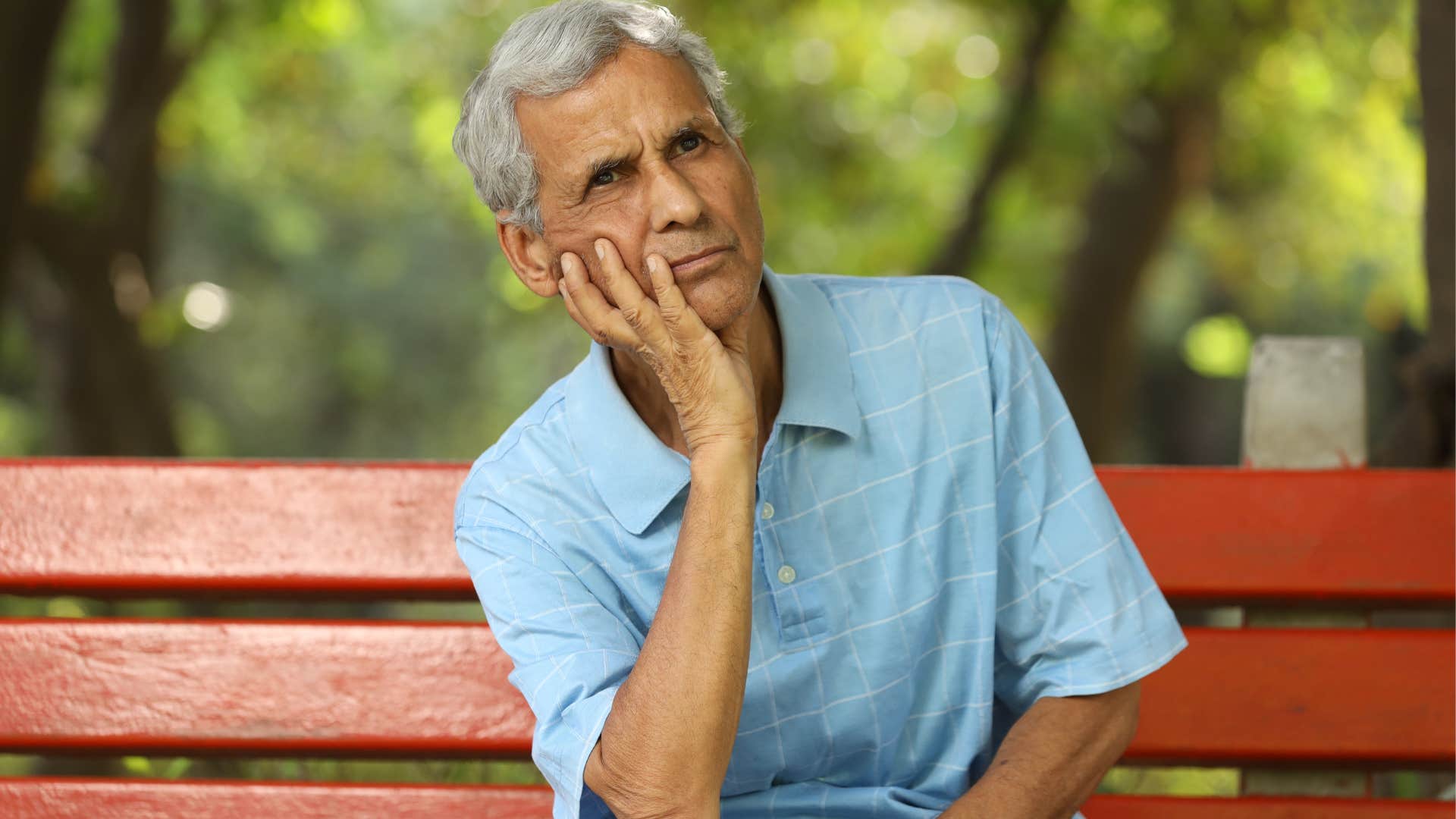 Man who's a complex thinker sitting on a park bench.