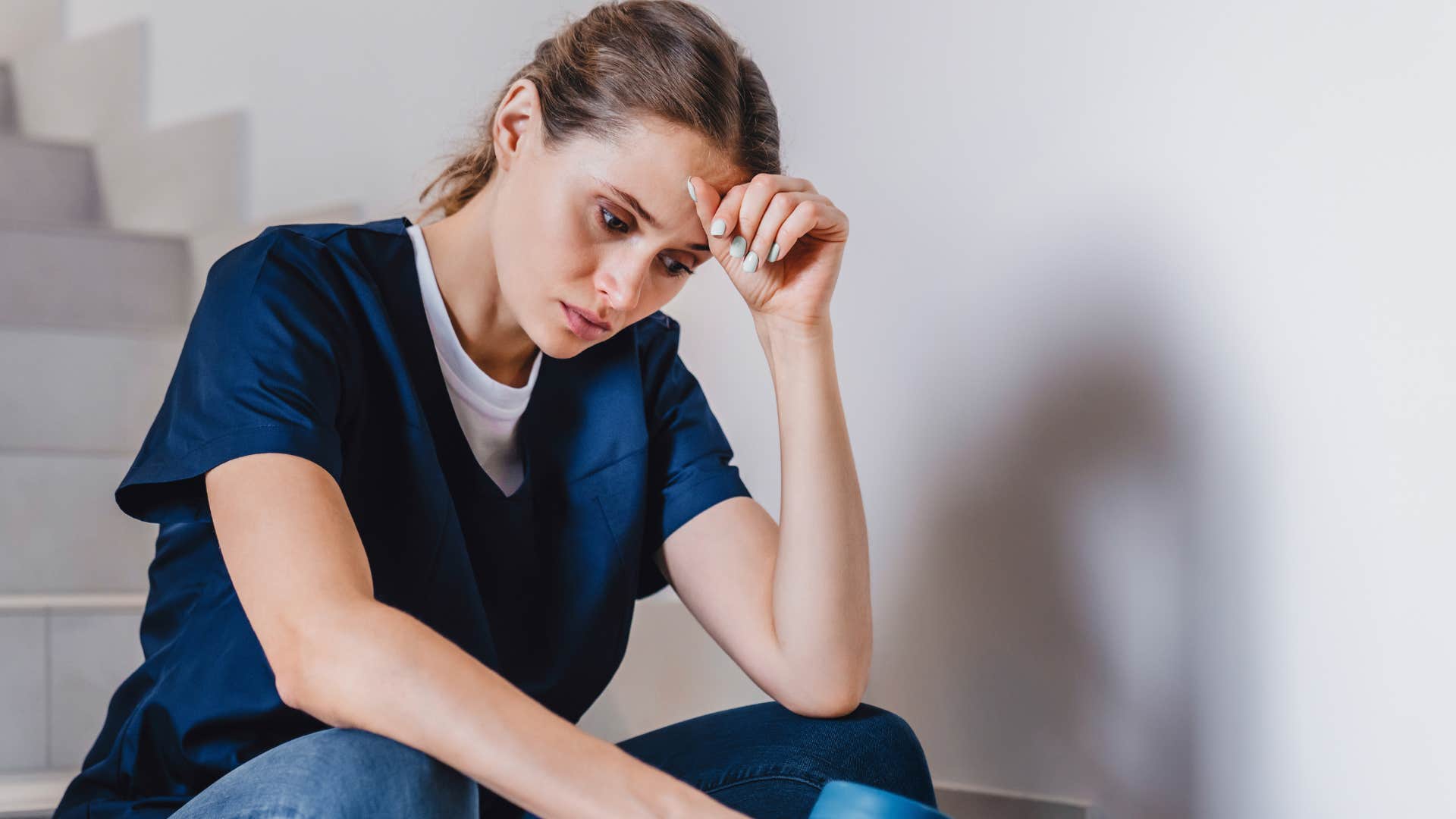 Woman who fears being wrong sitting and holding her head.