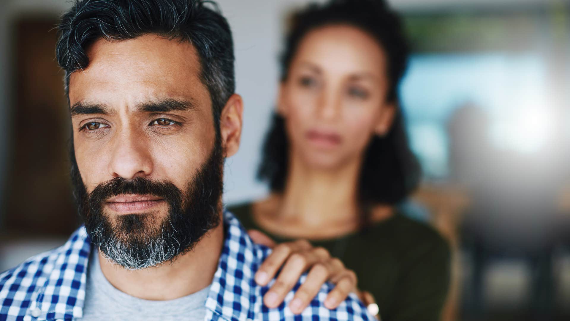 Man who's less confident than his partner turned away from her.