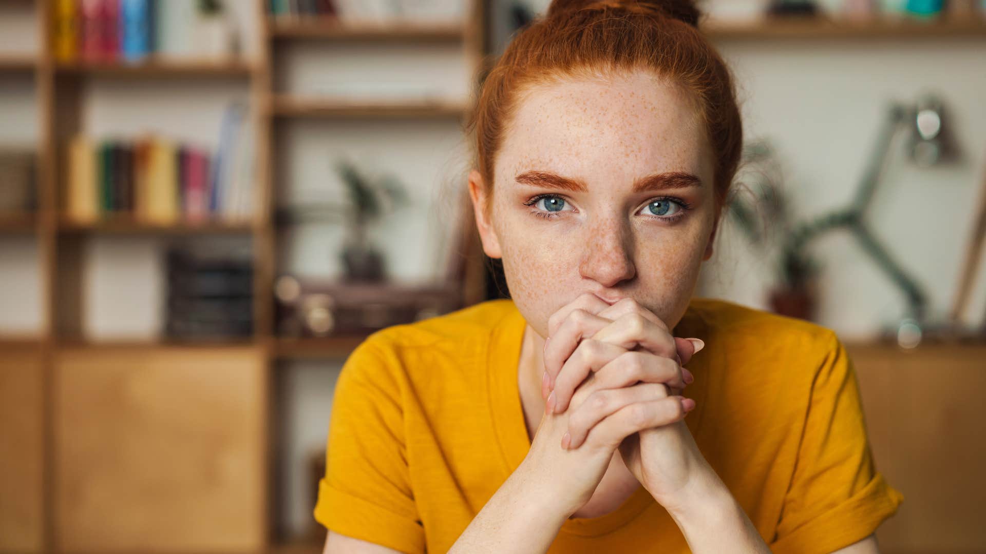 Woman who's been held to unrealistic expectations looking seriously at the camera.