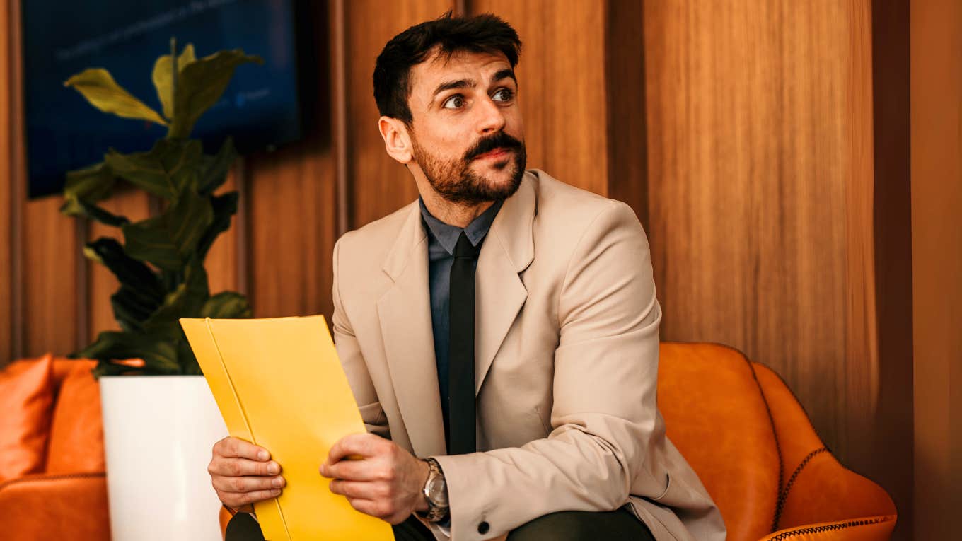 Red-Flag Phrases Only Sketchy Companies Use In Their Job Descriptions Man waiting for a interview with a sketchy company.