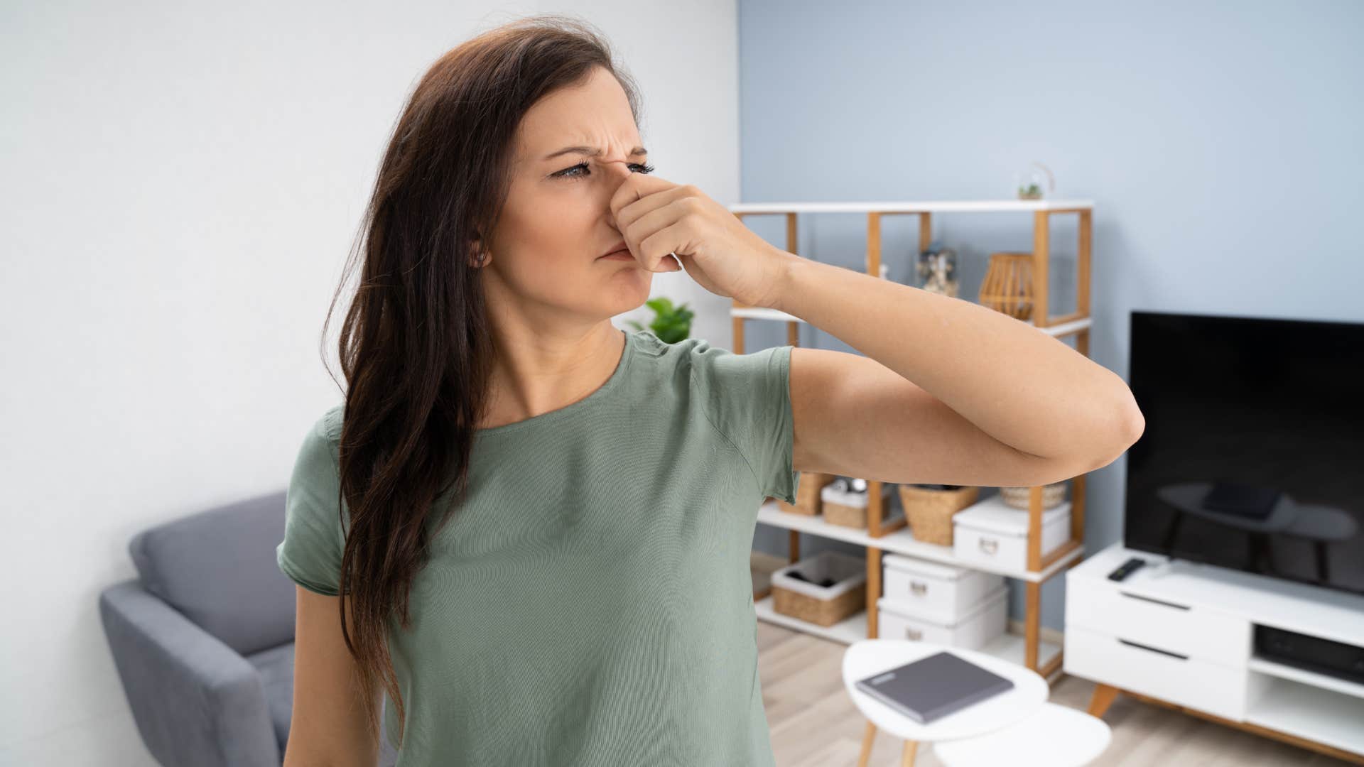 woman holding her nose from unpleasant smell