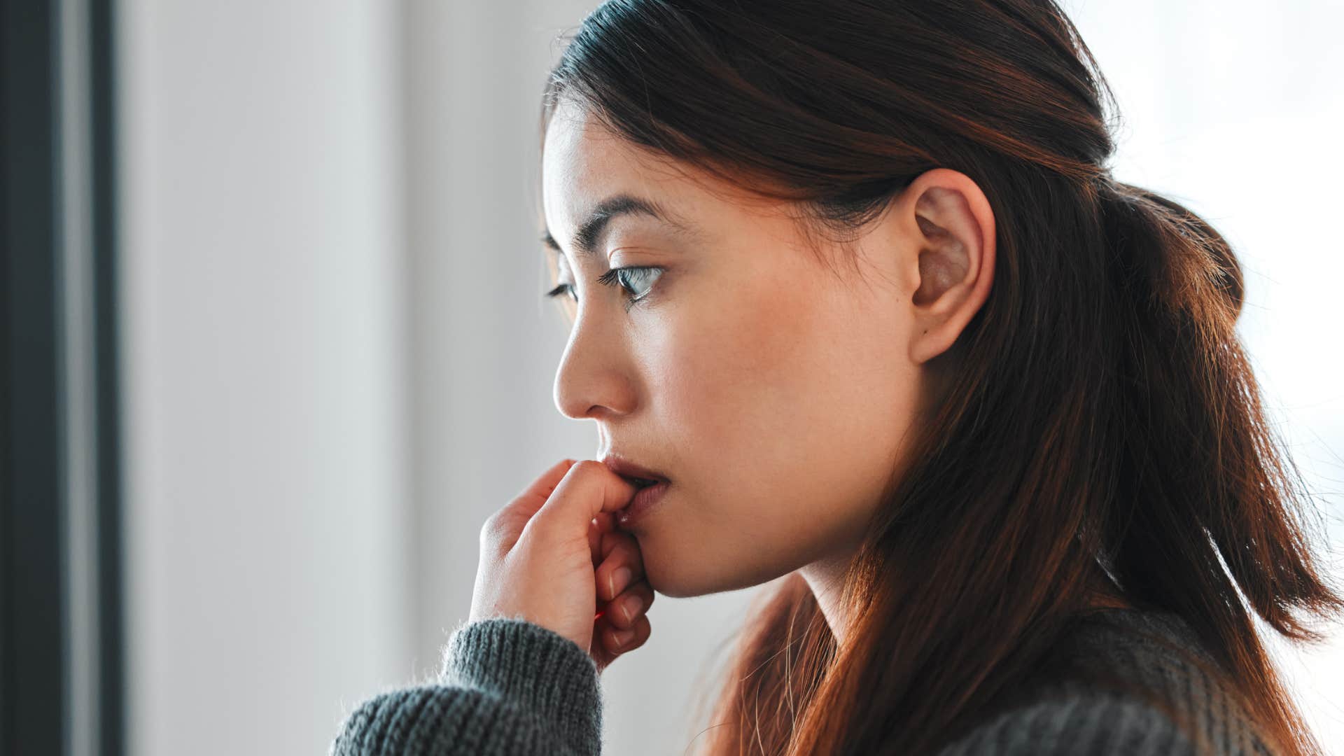 woman with emotional trauma biting nails and overthinking