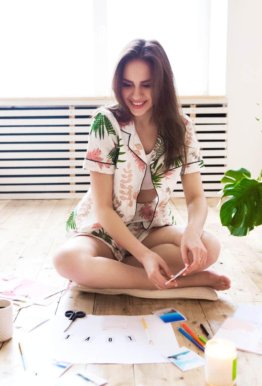 Woman using vision board and trusting the Universe to deliver her manifestation even though she isn't sure what it is