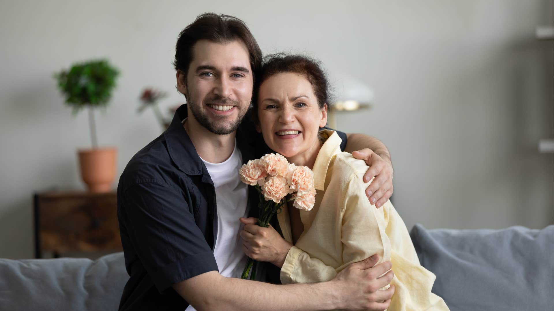 man who's too attached to his mom giving her flowers