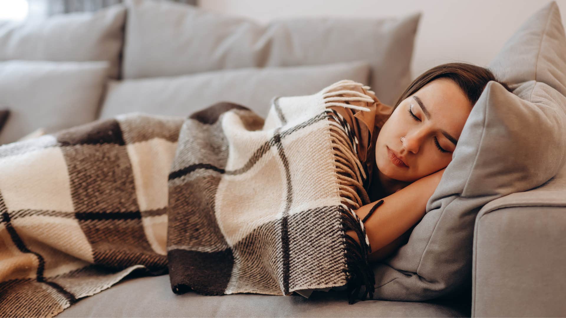 a woman falls fast asleep on her couch