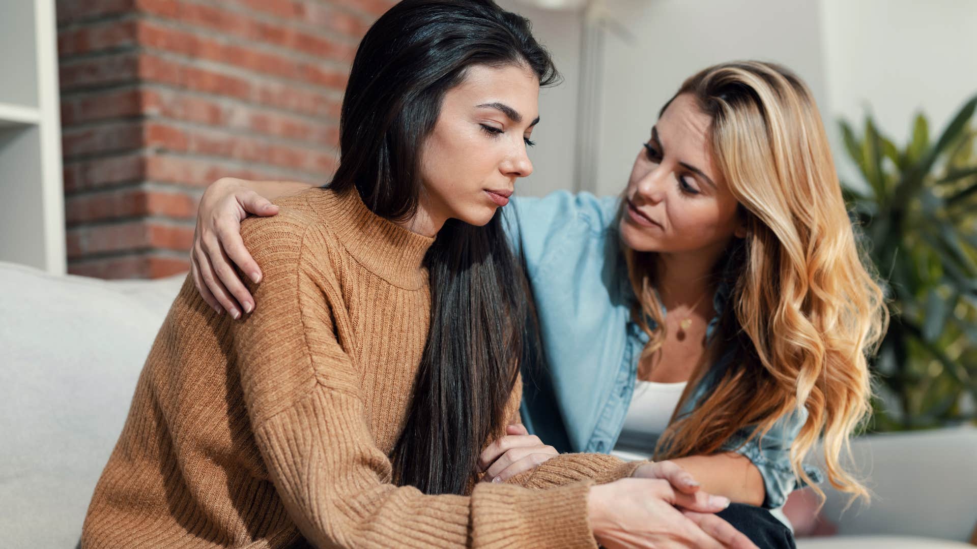 sensitive woman noticing friend hurting and comforting her