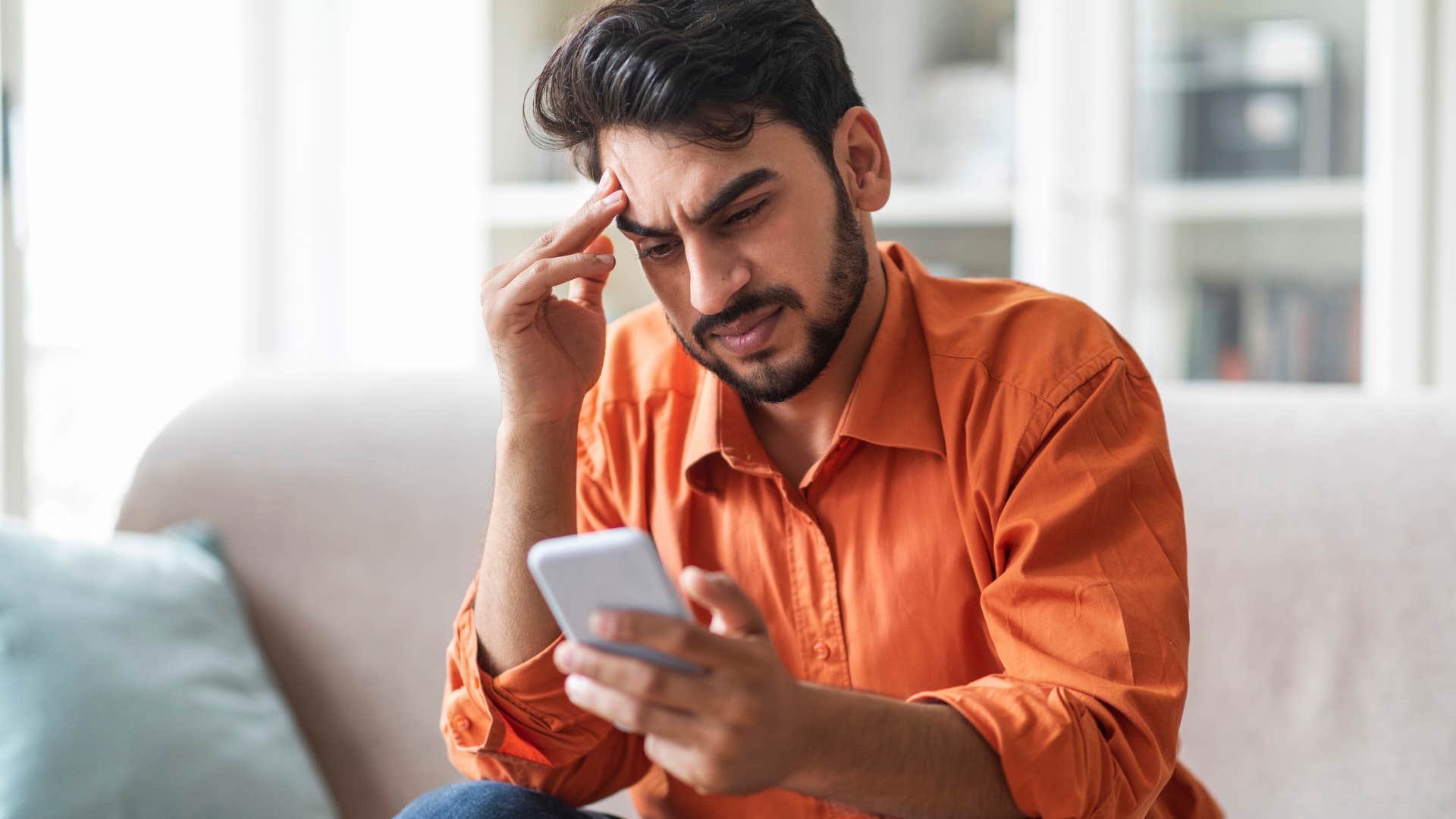 sensitive man upset looking at social issues on phone