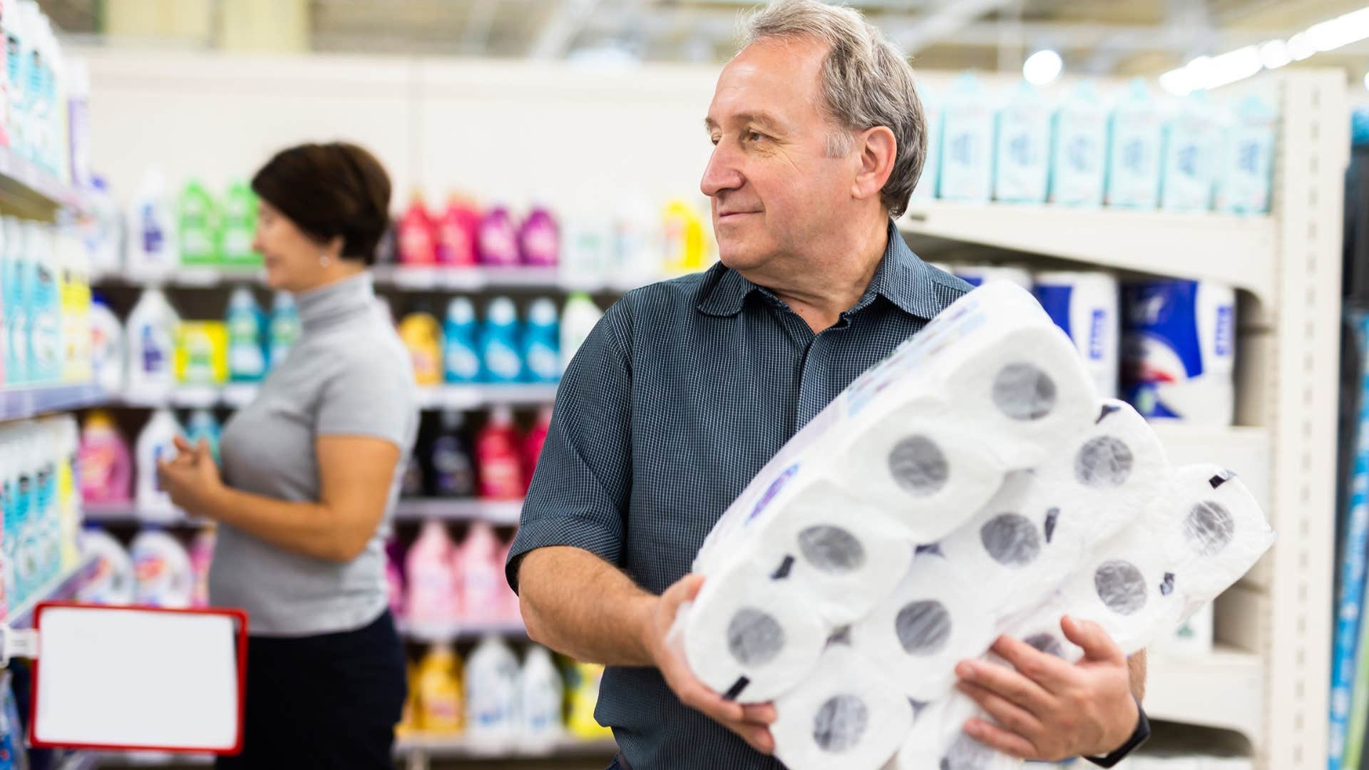 man holding toilet paper to buy in bulk at the store