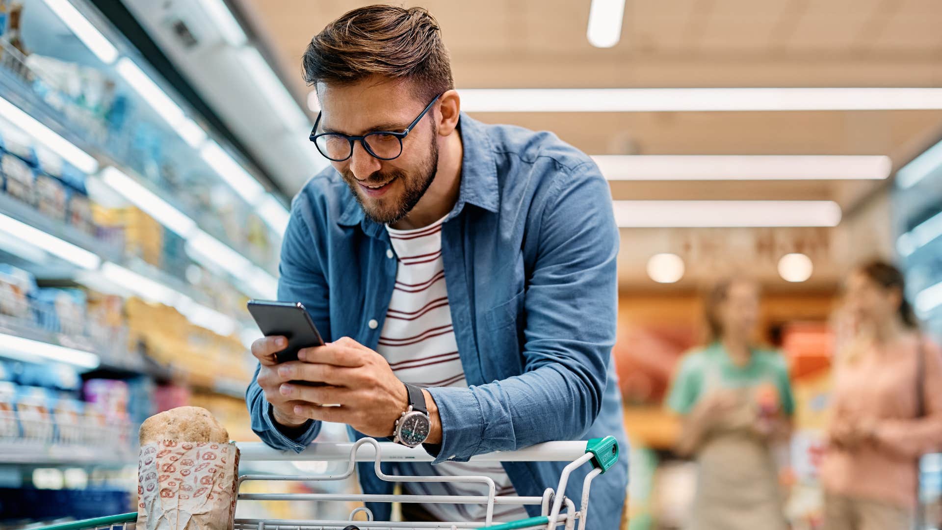 man looking at his shopping list at grocery store