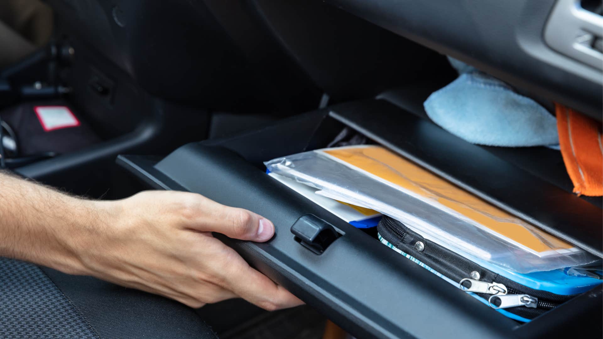 a man gets his registration papers from his glove compartment