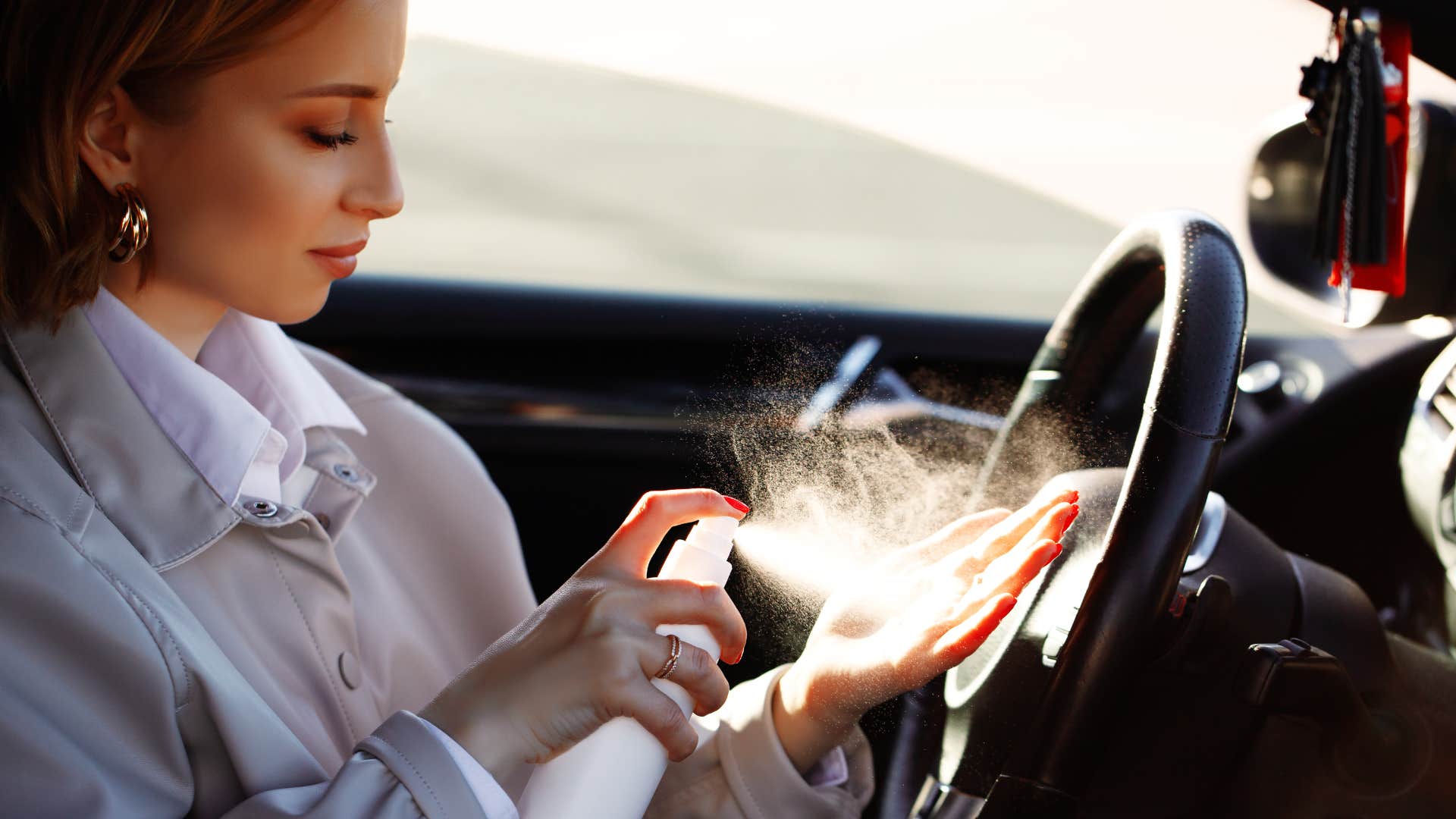 a woman uses hand sanitizer that she keeps in her car