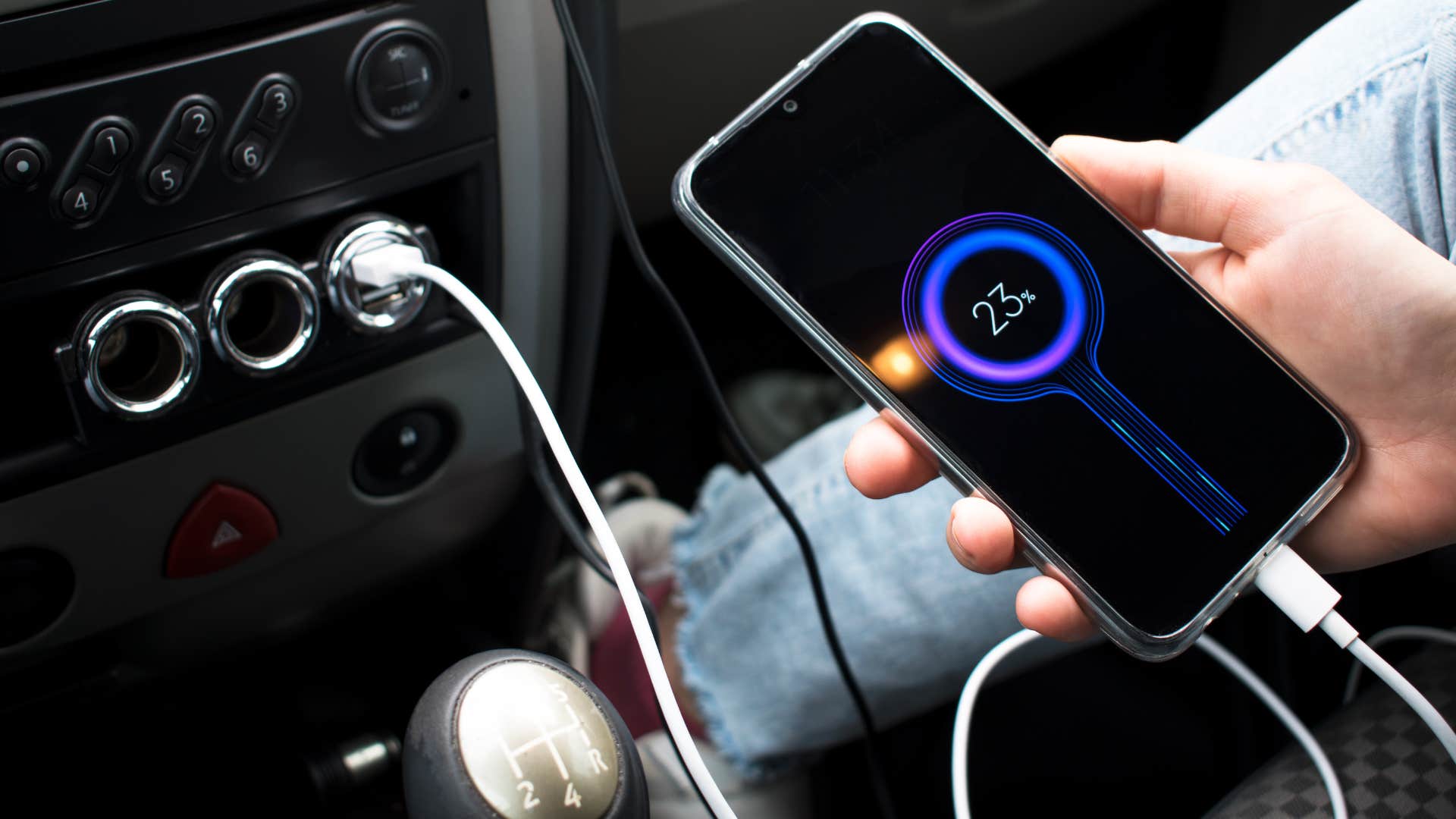 a woman charges her phone in the car
