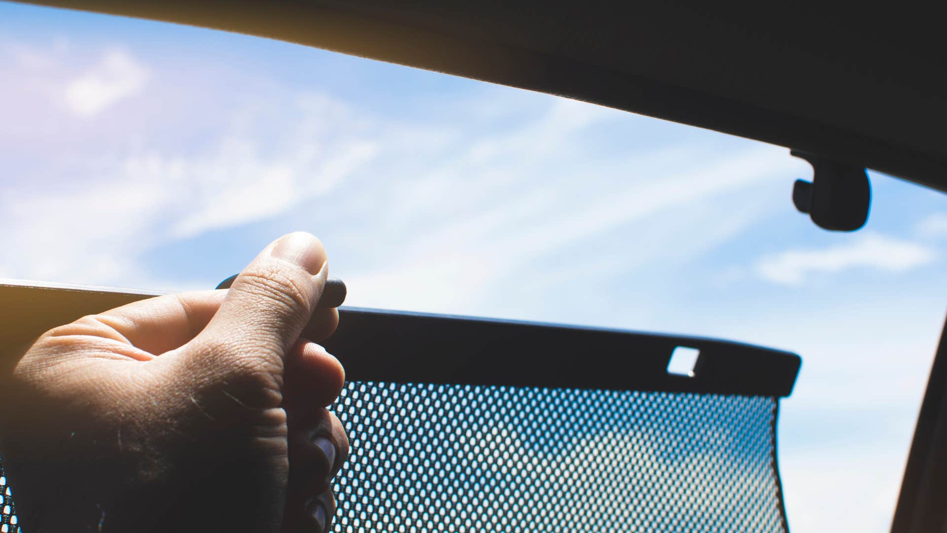 a man puts up sunshades in his car to protect it from the heat of the sunlight