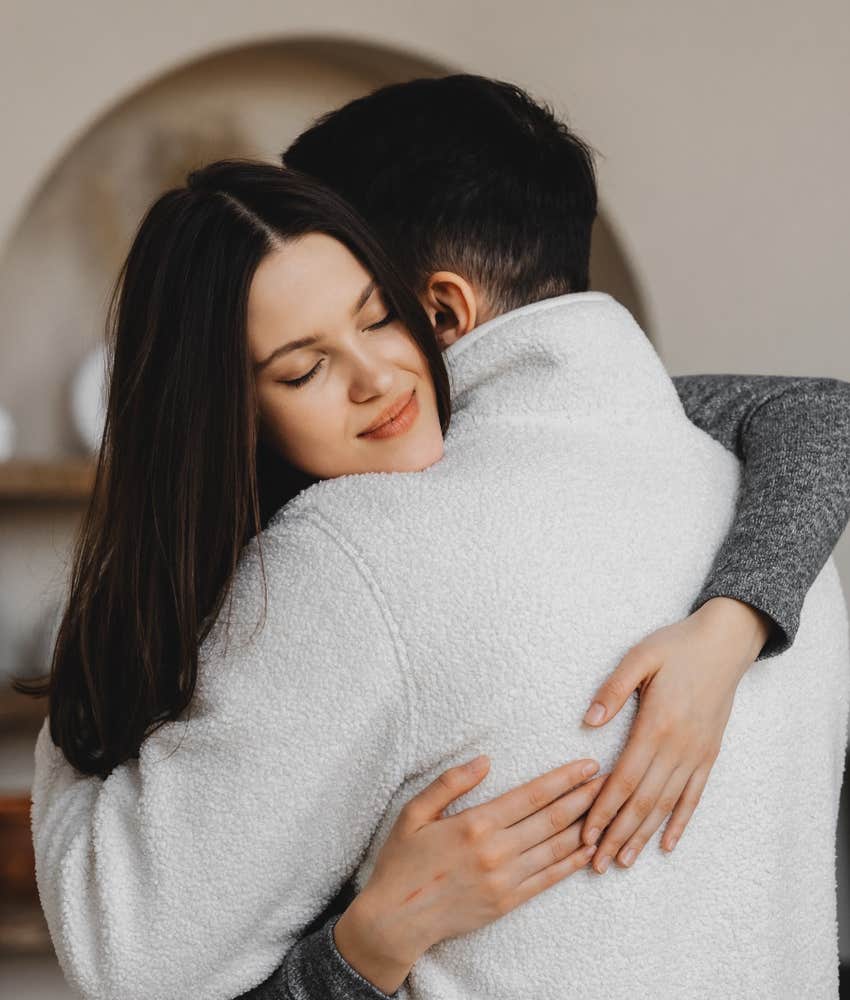 Two people hug.