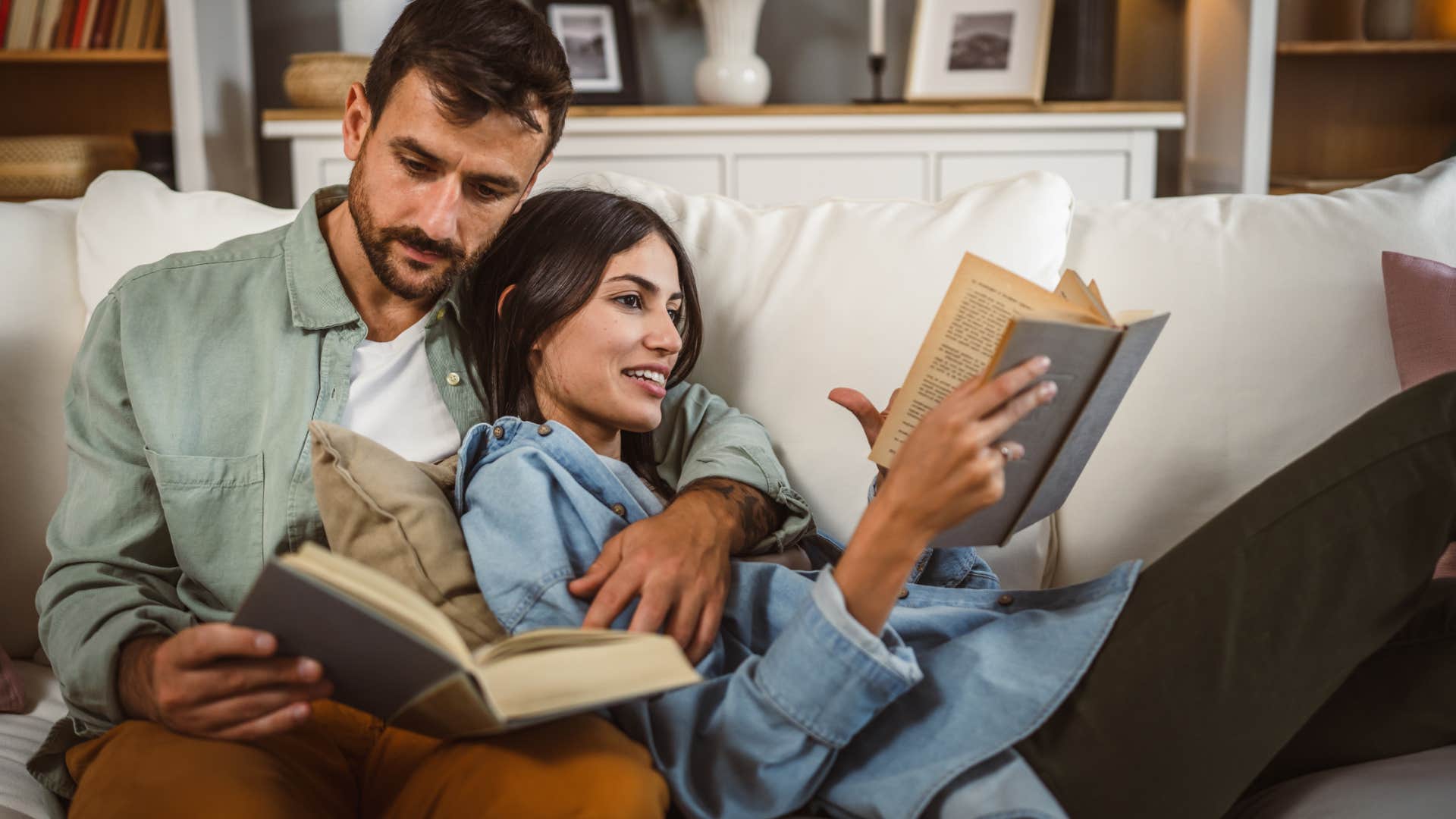 intellectually compatible couple reading books on the couch together