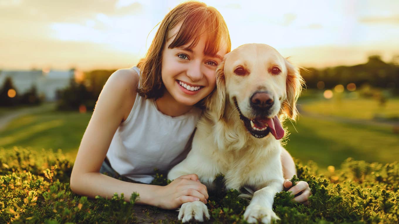 smiling woman and her happy dog in a field