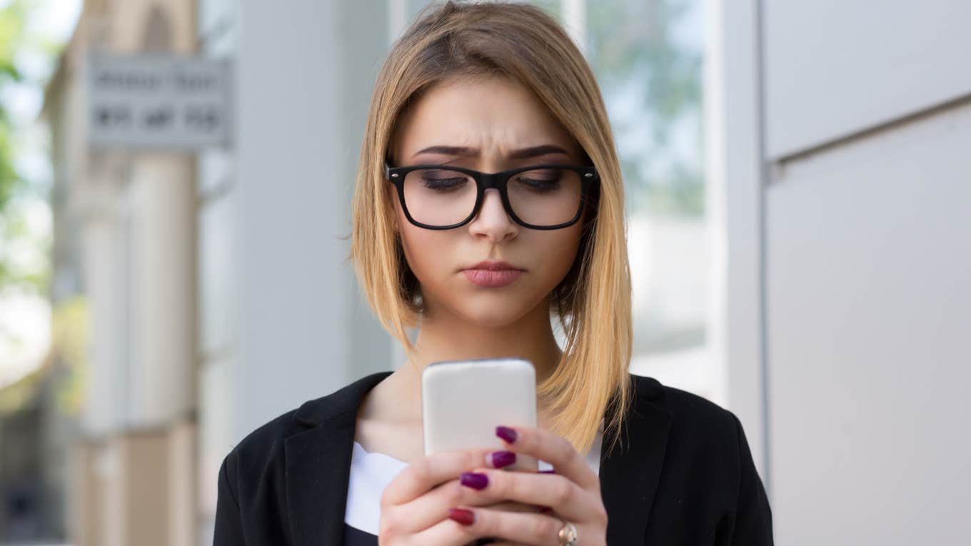 sad unhappy woman texting on her phone