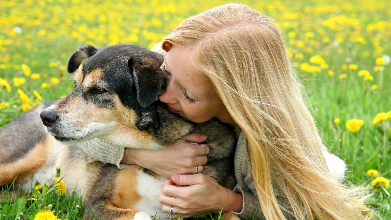 the color of your dog’s fur reveals the type of luck you attract, according to feng shui. Woman hugs dog.