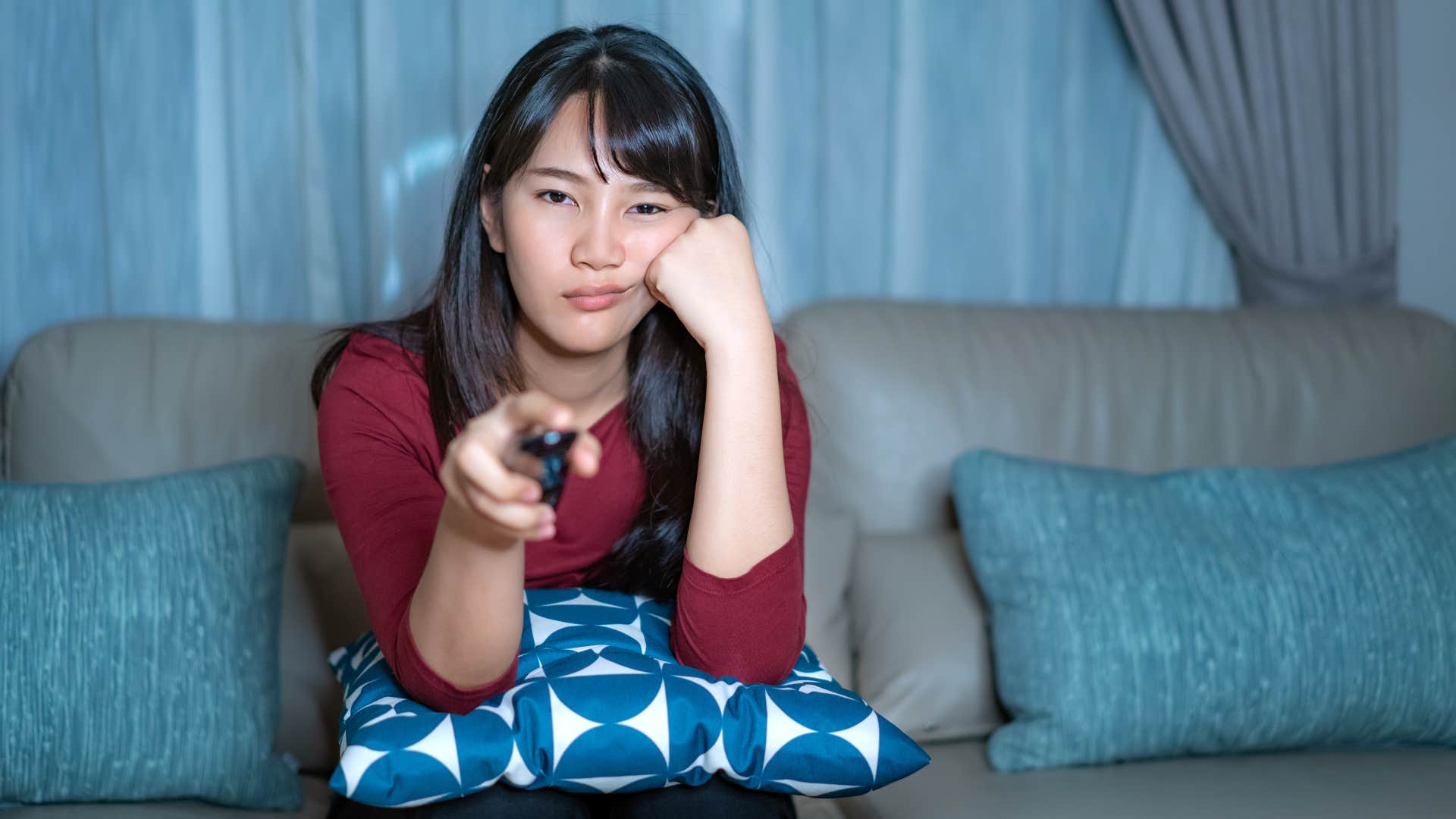 woman watching reality tv looking tired