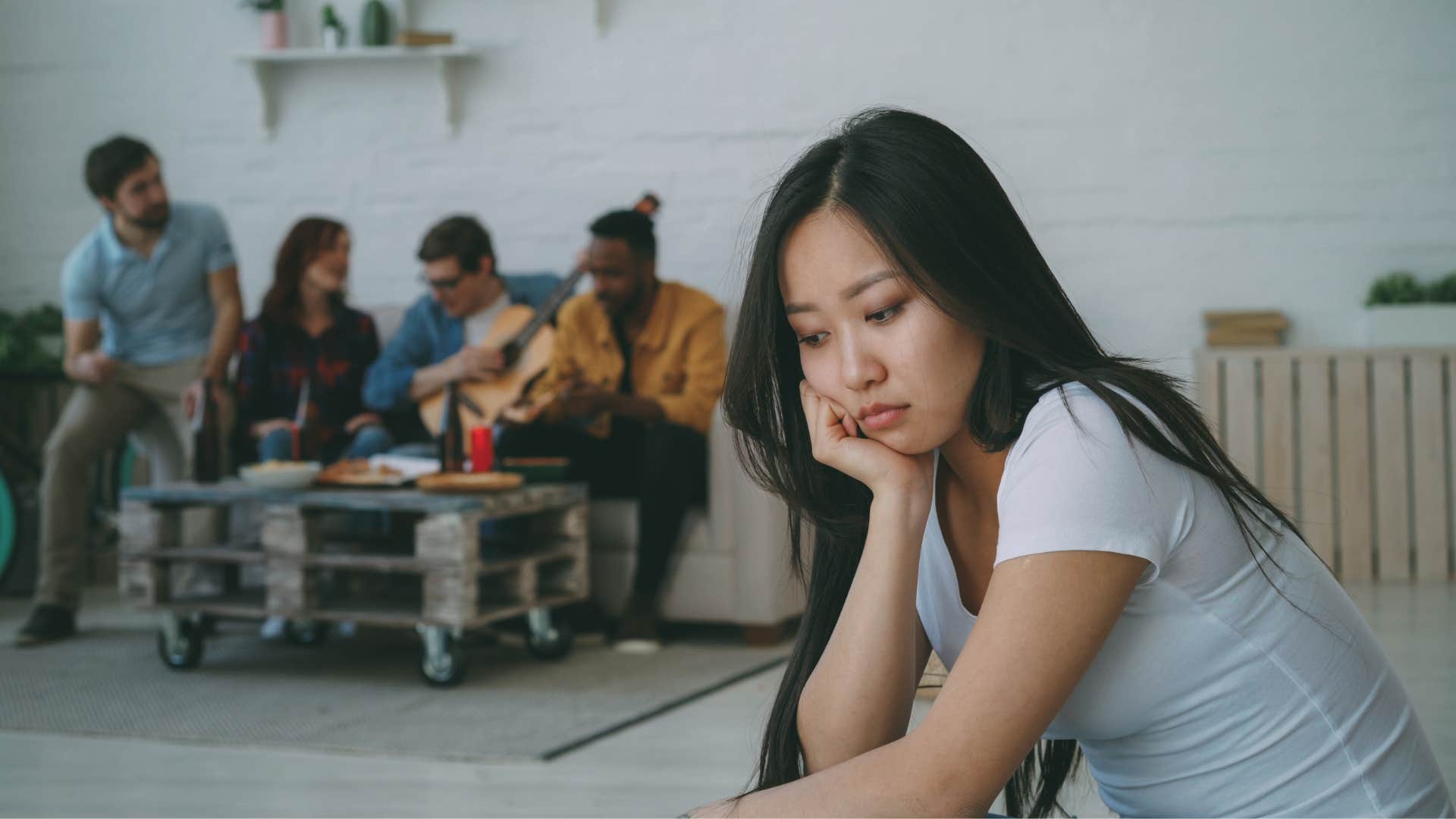 woman sitting alone at a party with no real connection