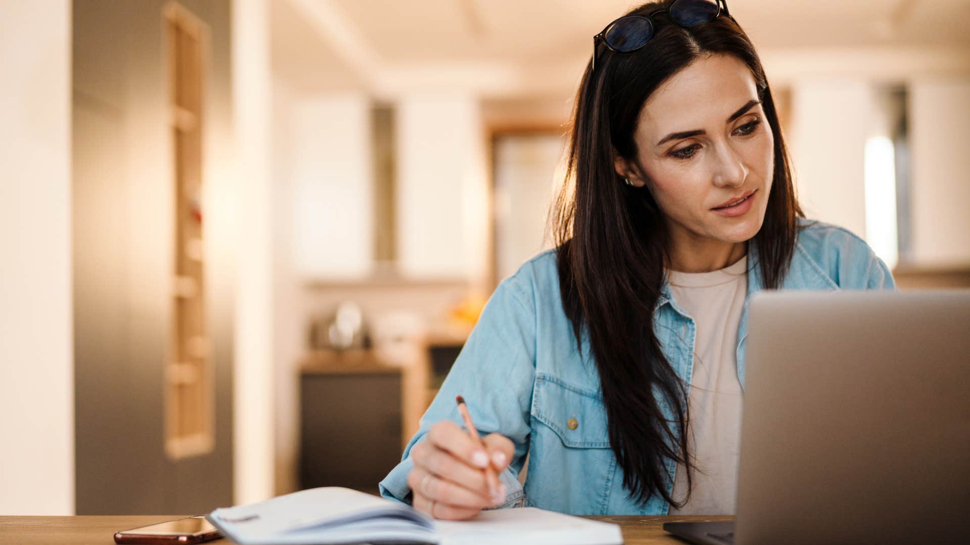 a gen z woman uses a printed calendar books to write down her appointments just like boomers