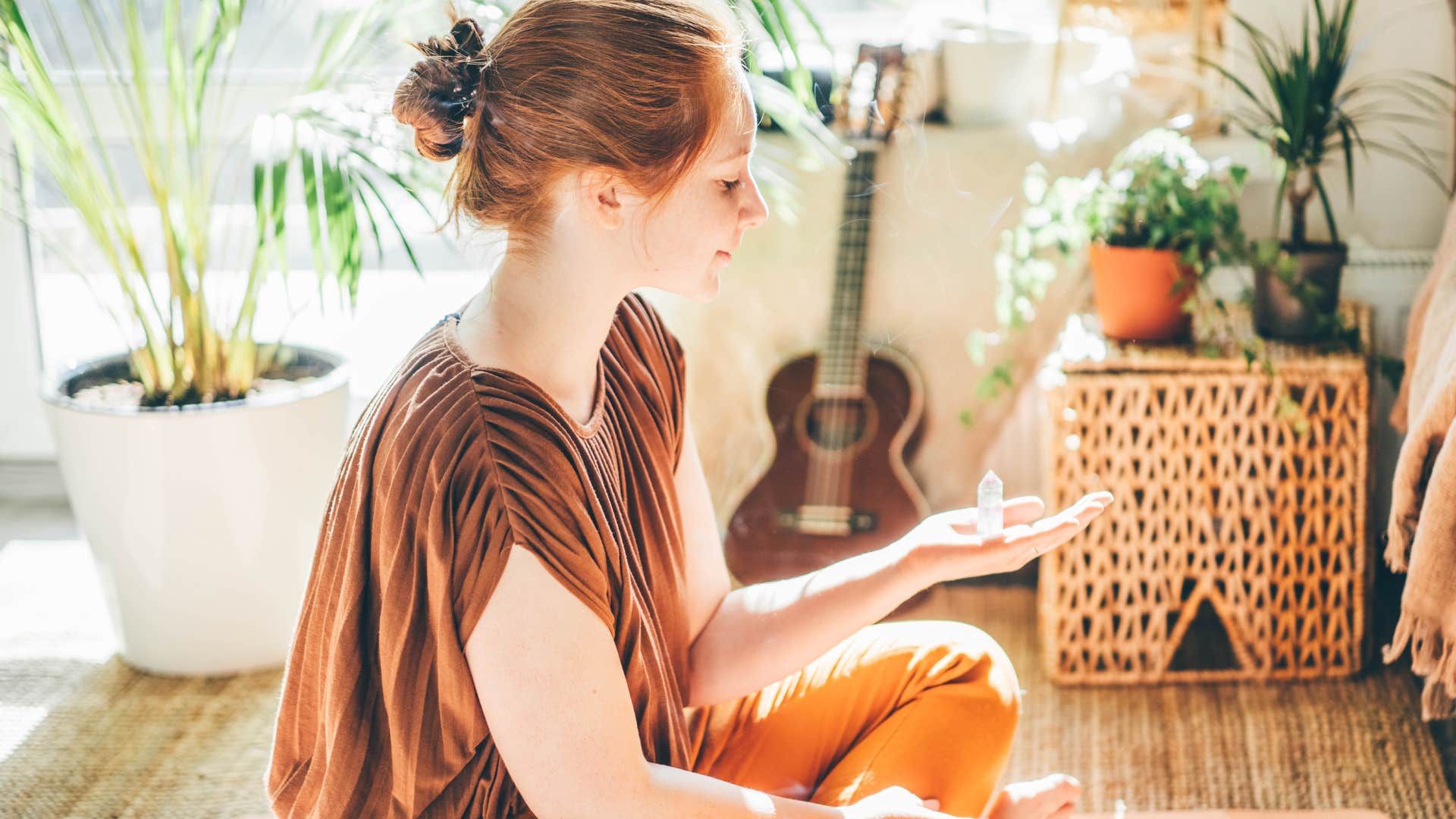 gen z woman holding crystals and meditating