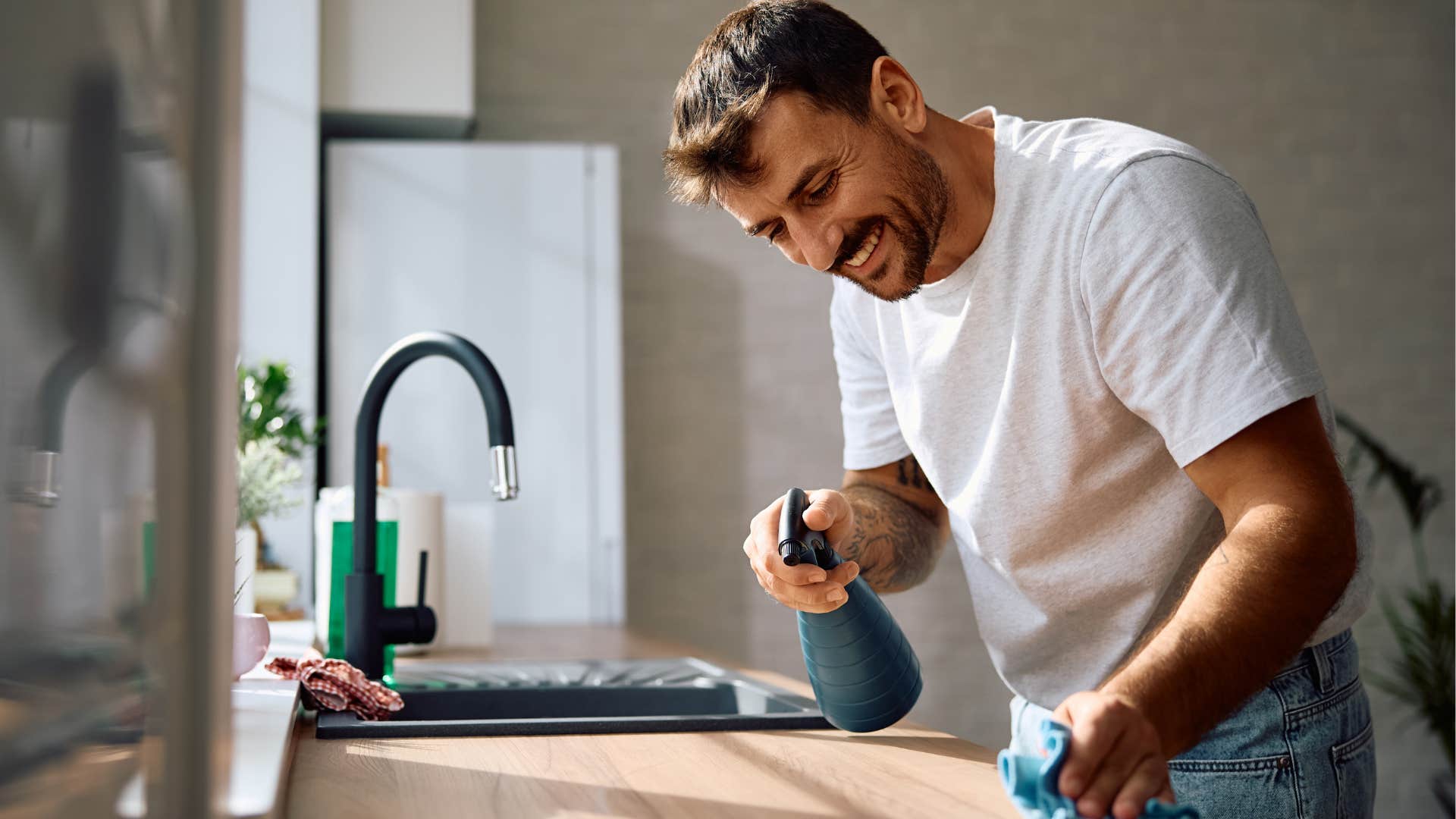 man spraying his desk to clean it