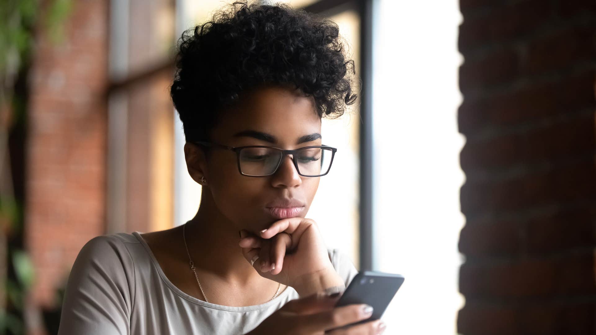 annoyed woman looking at phone thinking i'm too old for this