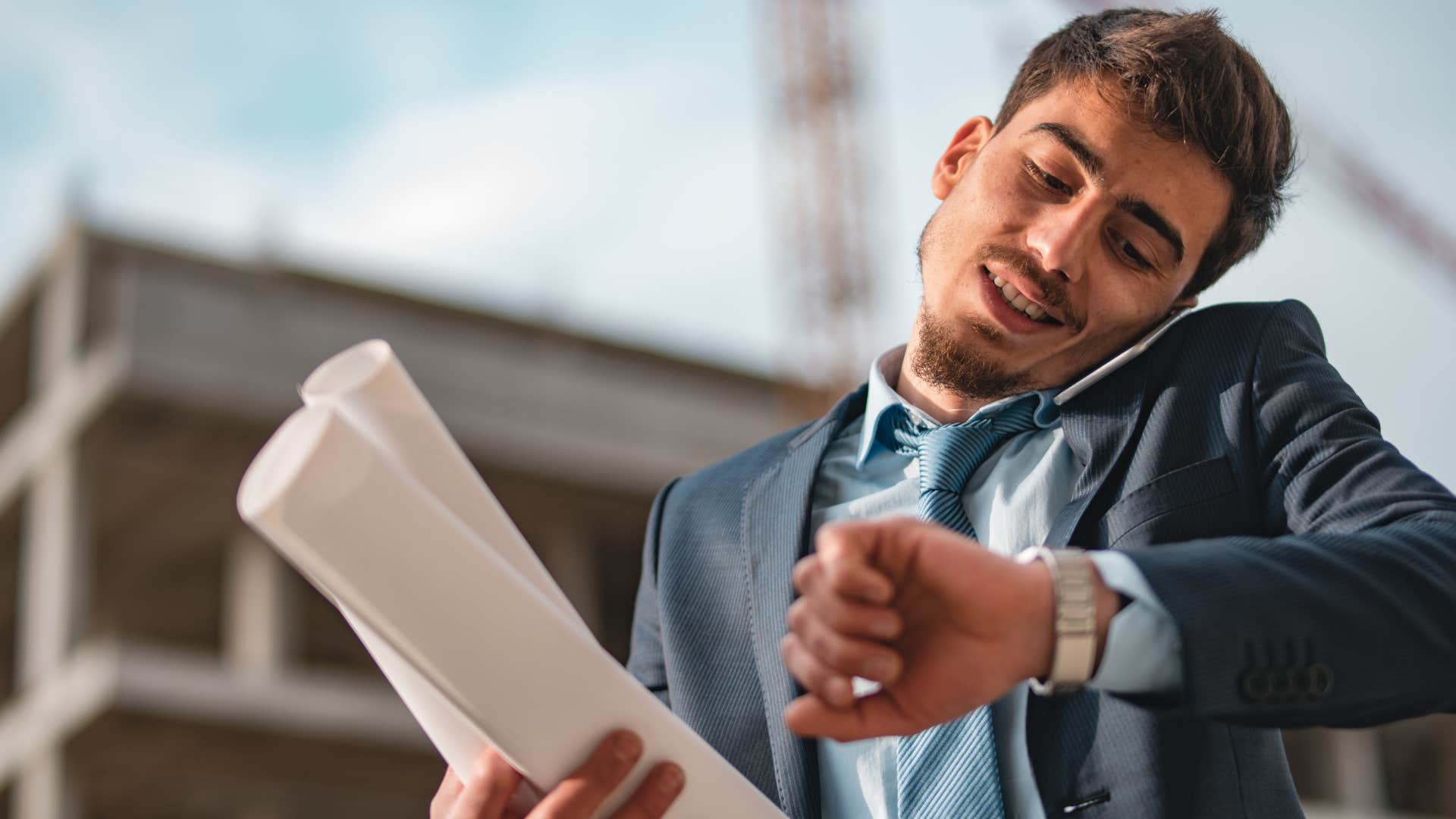 man on phone checking his watch waiting to leave