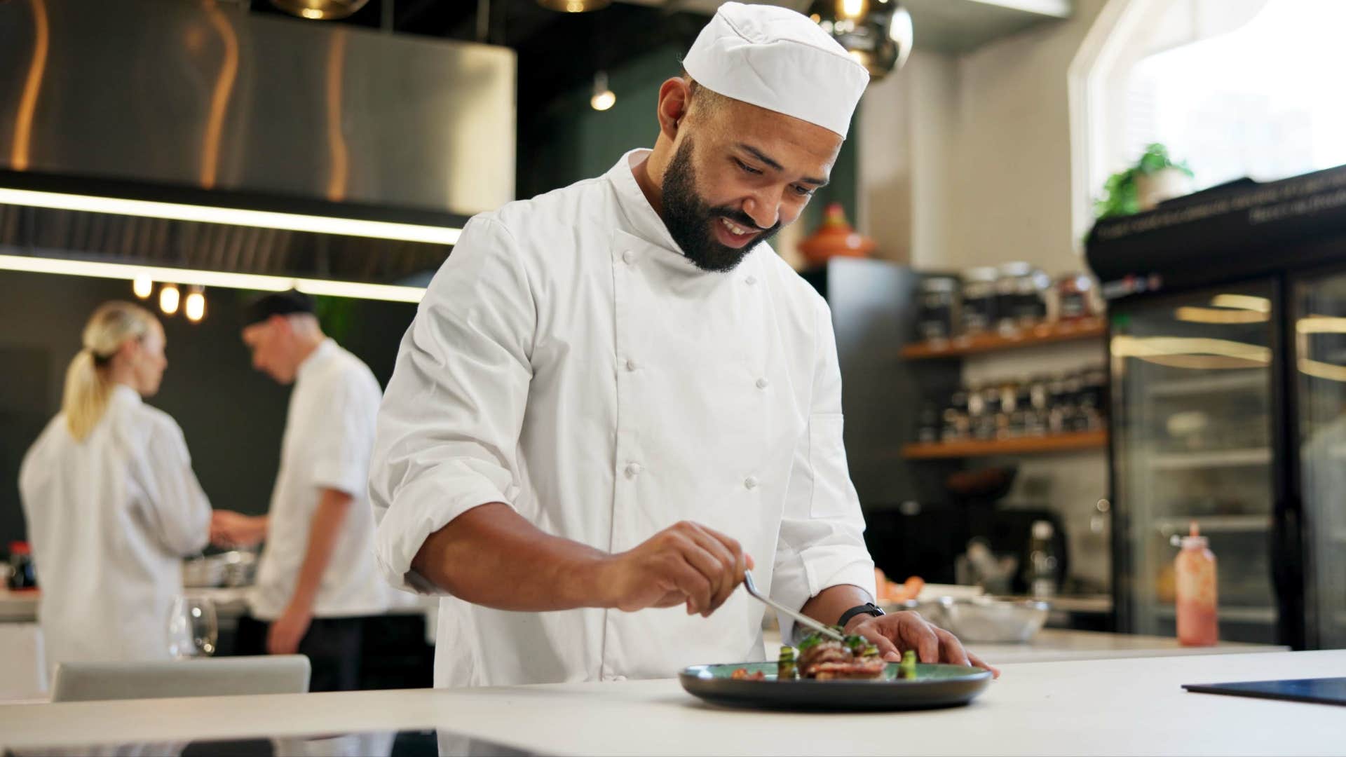 a chef in a michelin star restaurant prepares a tiny meal for his guests