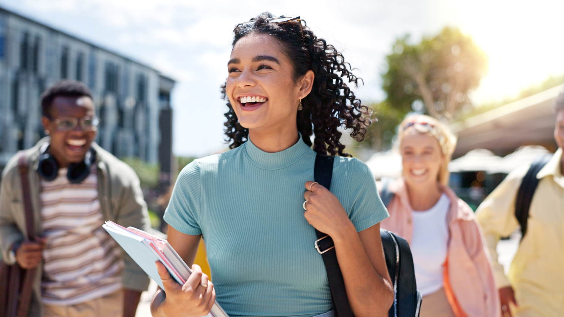 college student walking across campus smiling