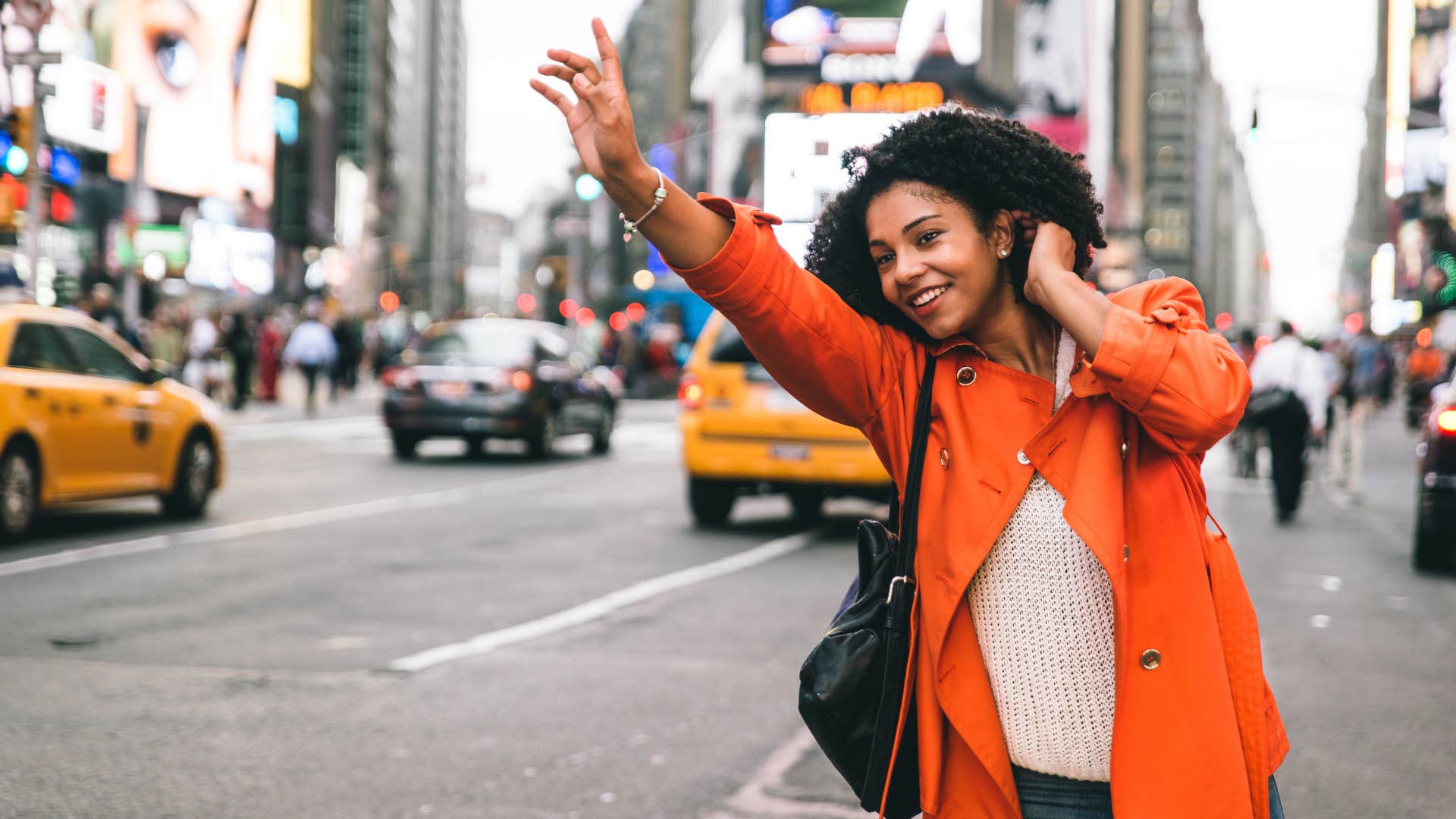 woman hailing a taxi in a new city