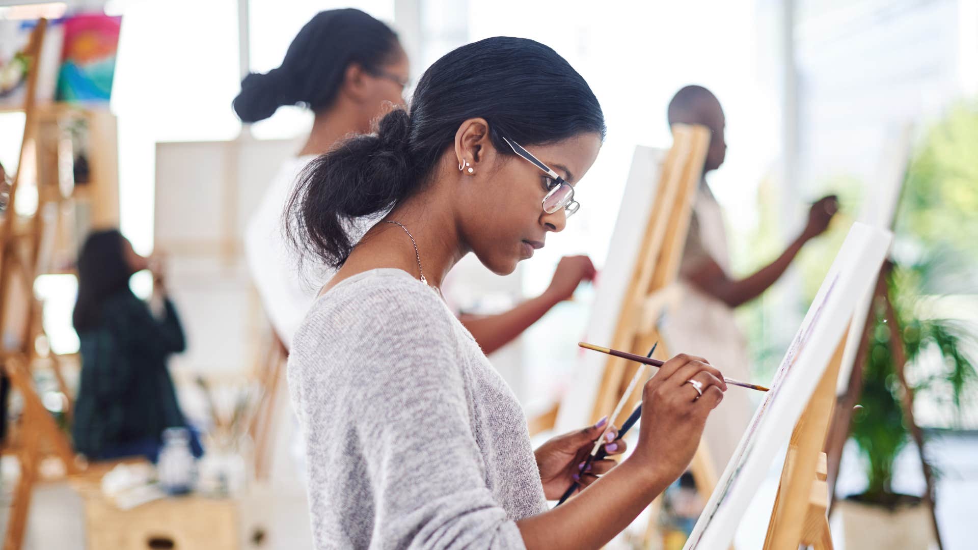 creative young woman painting in class