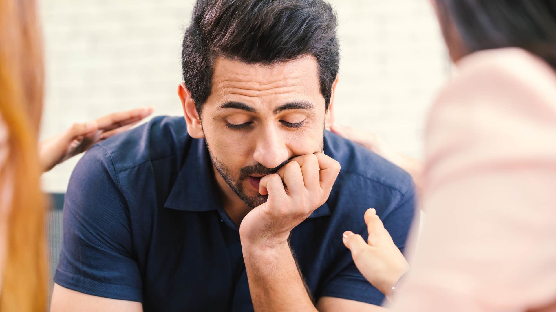 emotionally exhausted sad man avoiding helping people while surrounded by friends