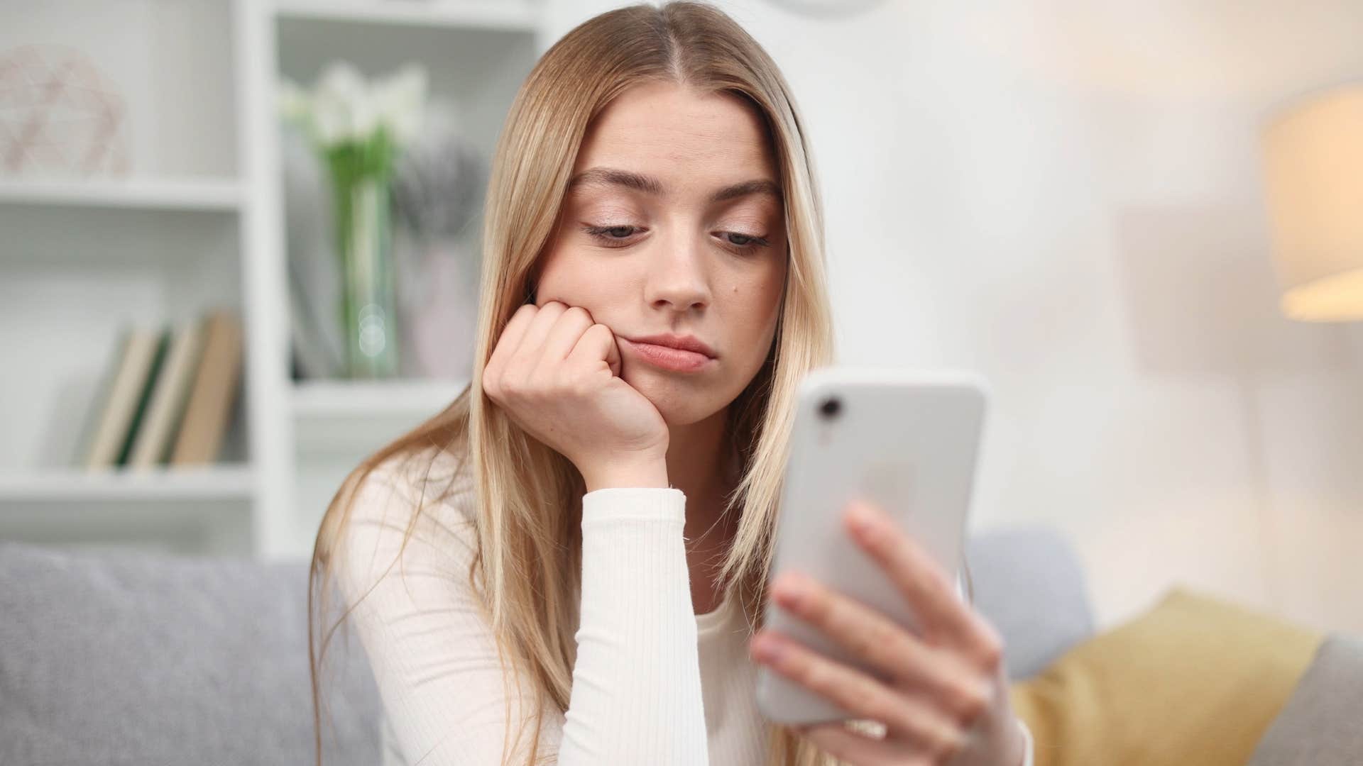 emotionally exhausted woman avoiding worldly events and news on her phone