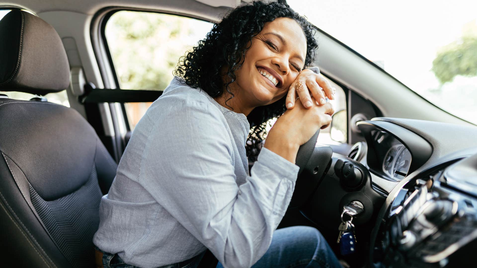 Woman smiling after buying a new car.