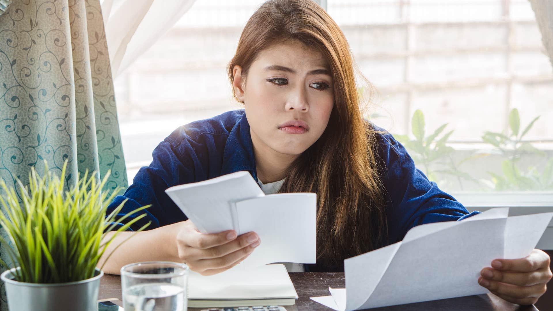 Woman doing bills after not budgeting at all.