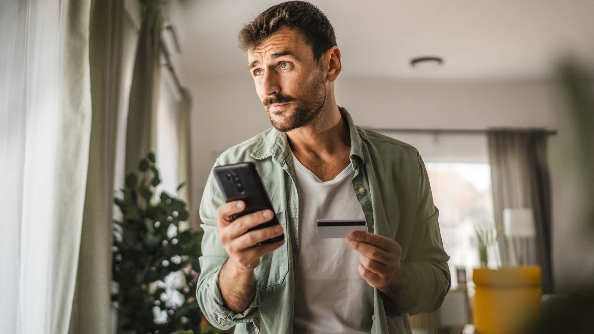 Man overusing their credit cards on his phone.